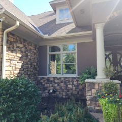Close-up view of cream-colored seamless gutters installed by a Minnesota gutter company, highlighting the smooth finish and precise installation