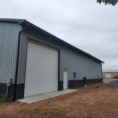 A sturdy pole barn in Orono, MN, featuring sleek black gutters installed for efficient water drainage and a modern appearance