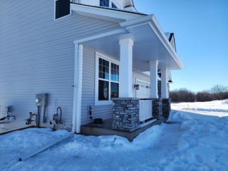 A home in Minneapolis covered in snow, featuring newly installed seamless gutters by a trusted local gutter company for optimal winter water management