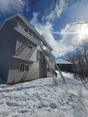 Snow scenes home in Minnesota with ladders extended ready for new seamless gutters