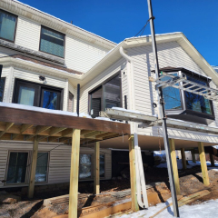 White home with ladders, scaffolding and getting new seamless gutters in Golden Valley MN