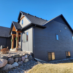 Gorgeous landscaped home stained in black with black seamless gutter installed by Long Lake gutter company