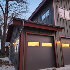 Brown colored home at dusk in winter showing burgundy colored seamless gutters by Call The Gutter Guys in Medina MN