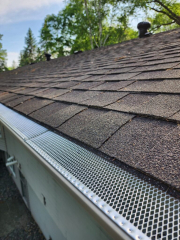 Roofline view of screen leaf guards installed by Call The Gutter Guys to help keep leaves and debris out