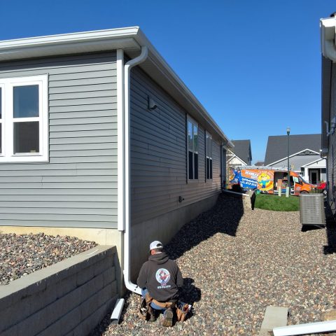 Rain gutters on town home in Delano Minnesota with zip hinges on downspouts