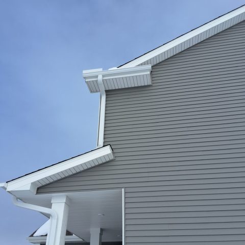 Photo showing white gutters installed by Call The Gutter Guys on a two story home using 5-inch gutters and 3x4 downspouts