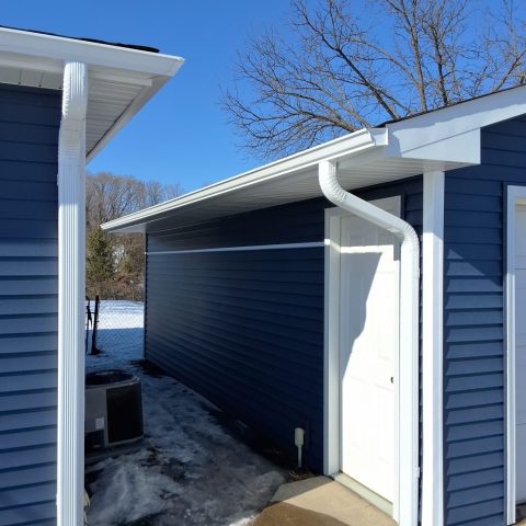 White seamless gutters and downspouts on garage in Plymouth MN installed by Call The Gutter Guys