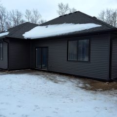 Black seamless gutters installed on a black new construction home in Breezy Point MN